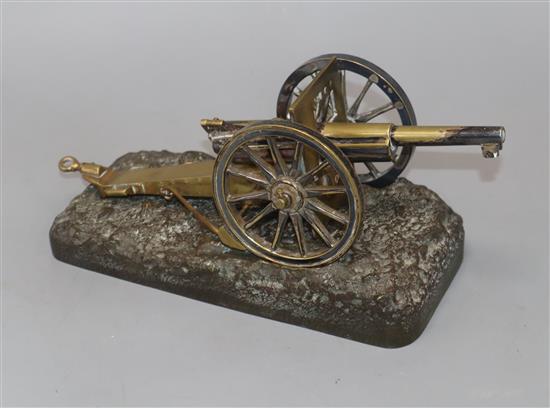 An early 20th century brass model cannon on cast bronze base